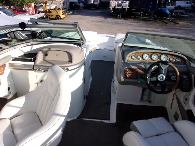 Slide: The Image of 2004 Cobalt 240SD boat interior with white seating and dashboard controls. - 5