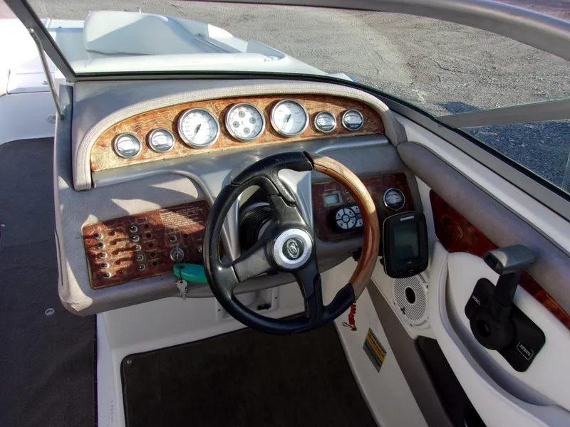 Slide: The Image of Dashboard of a 2004 Cobalt 240SD boat with wood accents and steering wheel. - 6