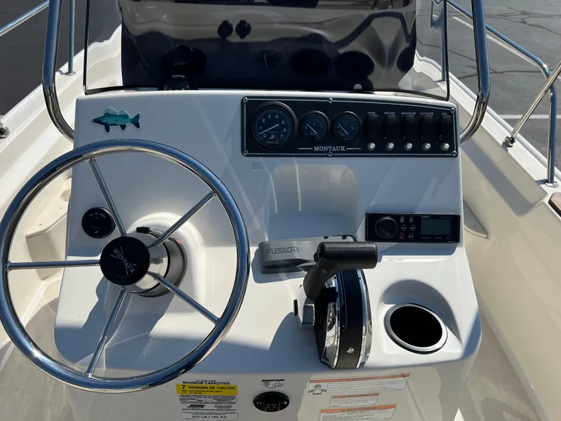 Slide: The Image of 2019 Boston Whaler 170 Montauk boat dashboard with steering wheel and control panel. - 9