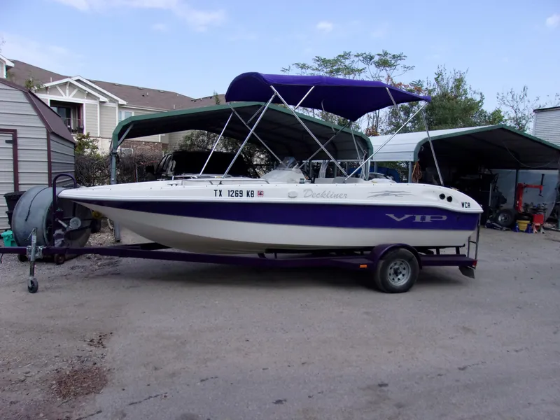 Slide: The Image of 2004 VIP Deckliner 191 boat on trailer with canopy, parked outdoors. - 1
