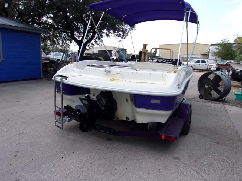Slide: The Image of 2004 VIP Deckliner 191 boat with purple canopy and trailer, parked outdoors. - 3