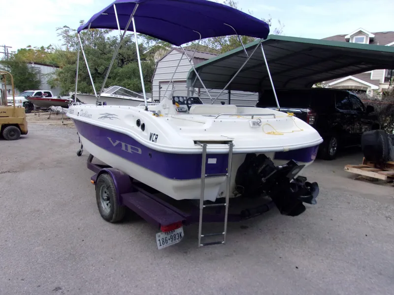 Slide: The Image of 2004 VIP Deckliner 191 boat with purple accents and canopy, parked on a trailer. - 4
