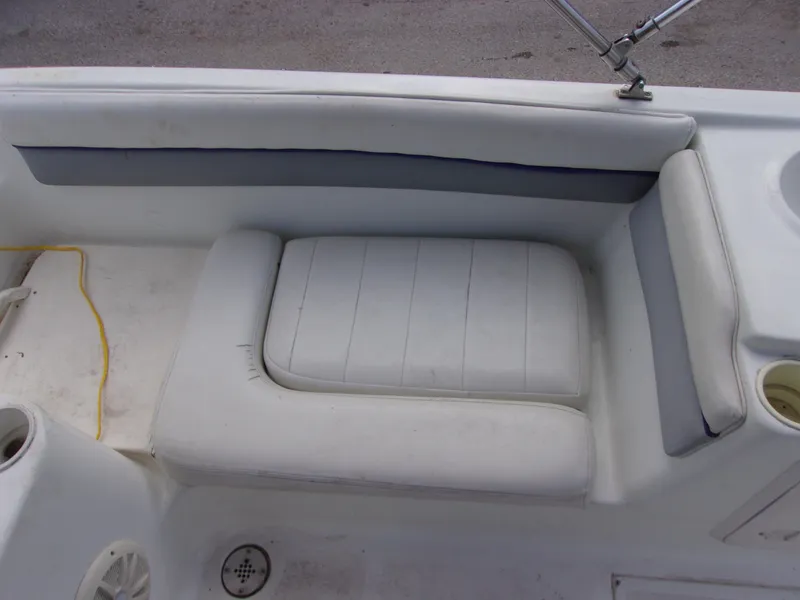 Slide: The Image of 2004 VIP Deckliner 191 boat interior seating with white cushions and storage compartment. - 8