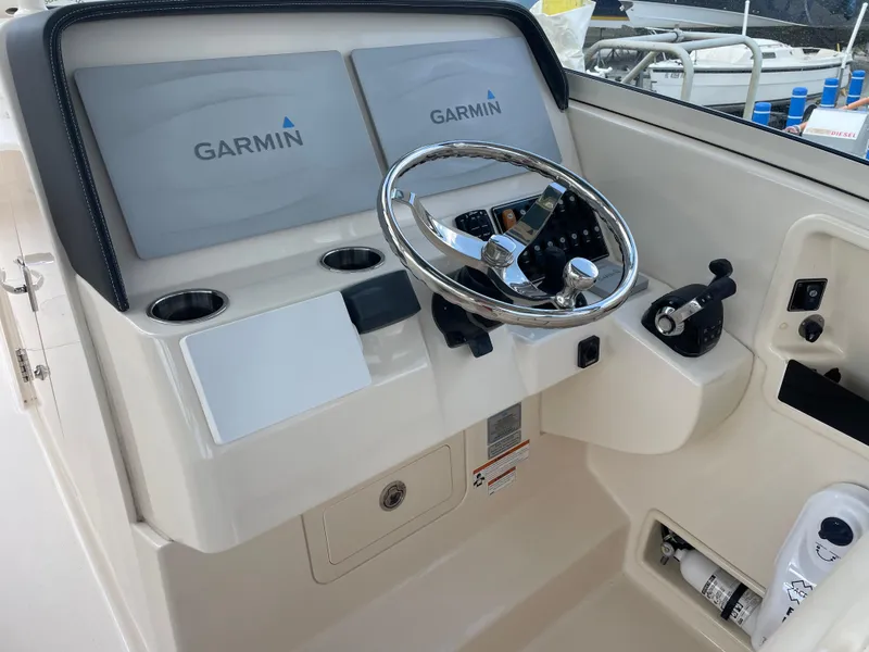 Slide: The Image of 2019 Grady-White Freedom 325 helm with Garmin displays and steering wheel. - 12