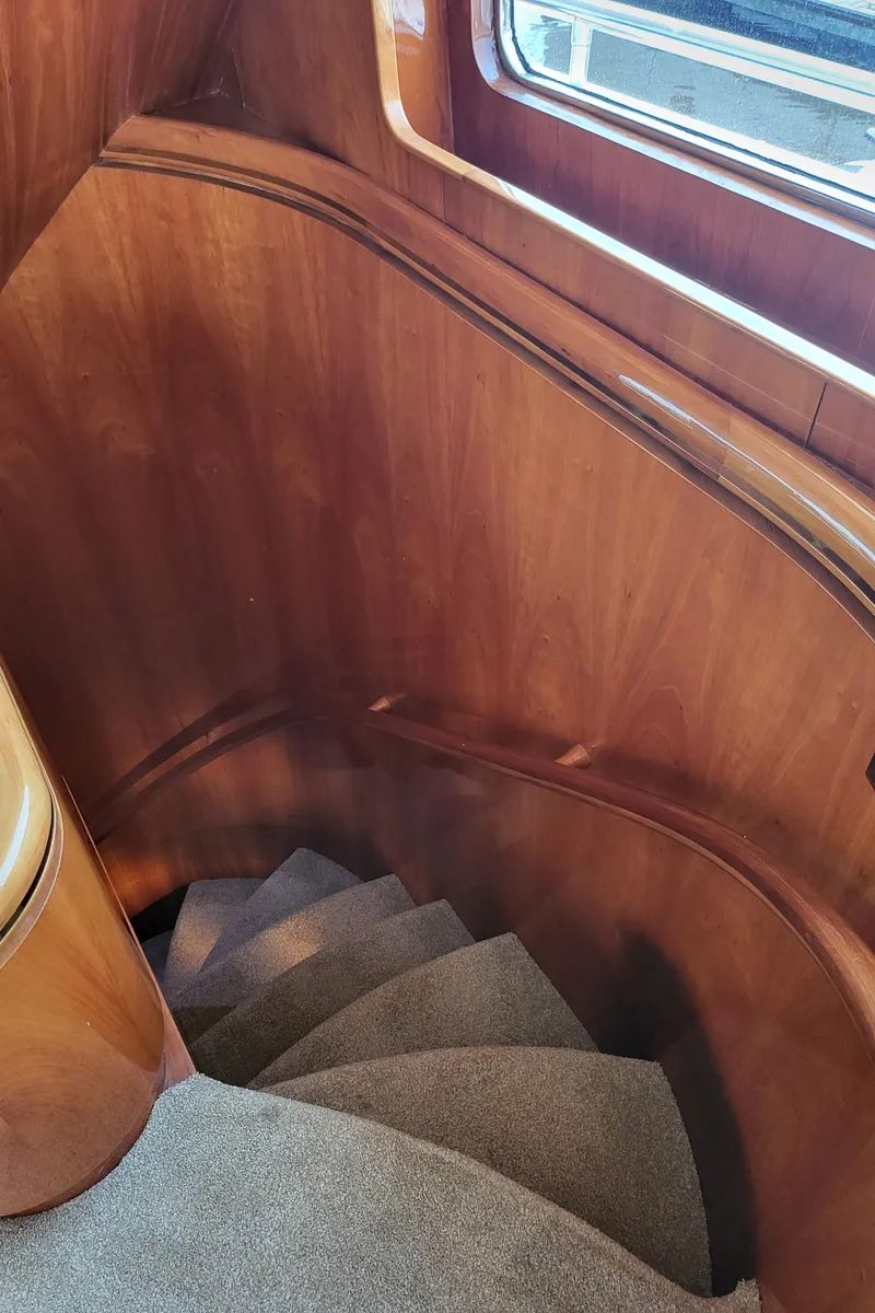 Slide: The Image of Curved wooden staircase inside 2000 Horizon 74 Motor Yacht, featuring elegant design and carpeting. - 40