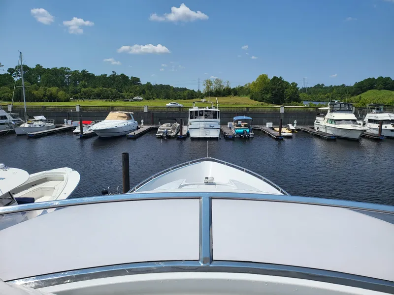 Slide: The Image of Bow view of a 2000 Horizon 74 Motor Yacht docked in a marina under a clear sky. - 9