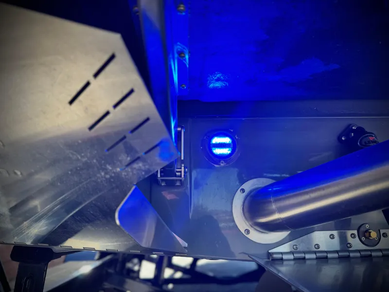 Slide: The Image of 2022 Tigé ATX 24 Type s boat underside with blue LED light and metal components. - 12