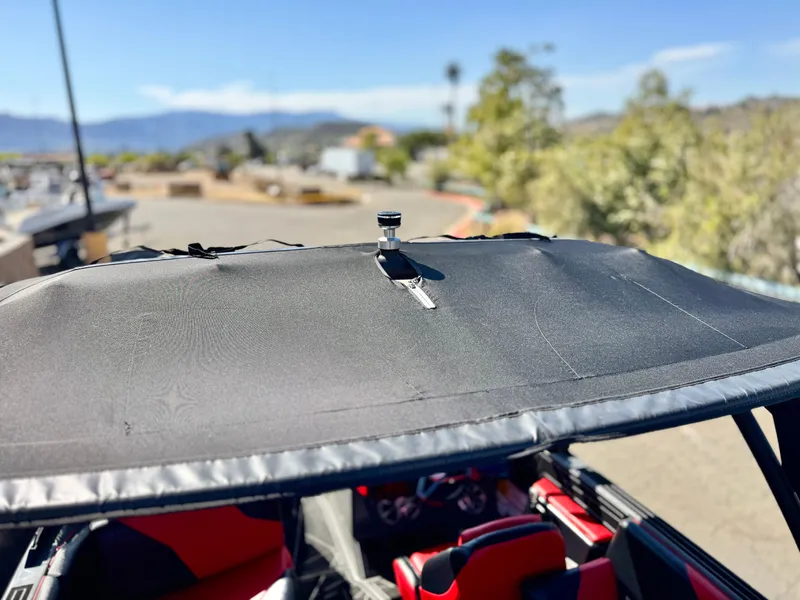 Slide: The Image of 2022 Tigé ATX 24 Type s boat with black canopy and red interior, outdoors. - 14