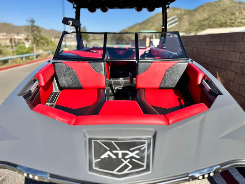 Slide: The Image of 2022 Tigé ATX 24 Type s boat with red and black interior, parked outdoors. - 19