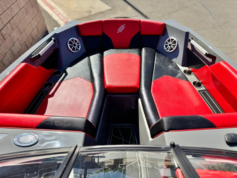 Slide: The Image of 2022 Tigé ATX 24 Type s boat interior with red and black seating, cup holders, and speakers. - 20