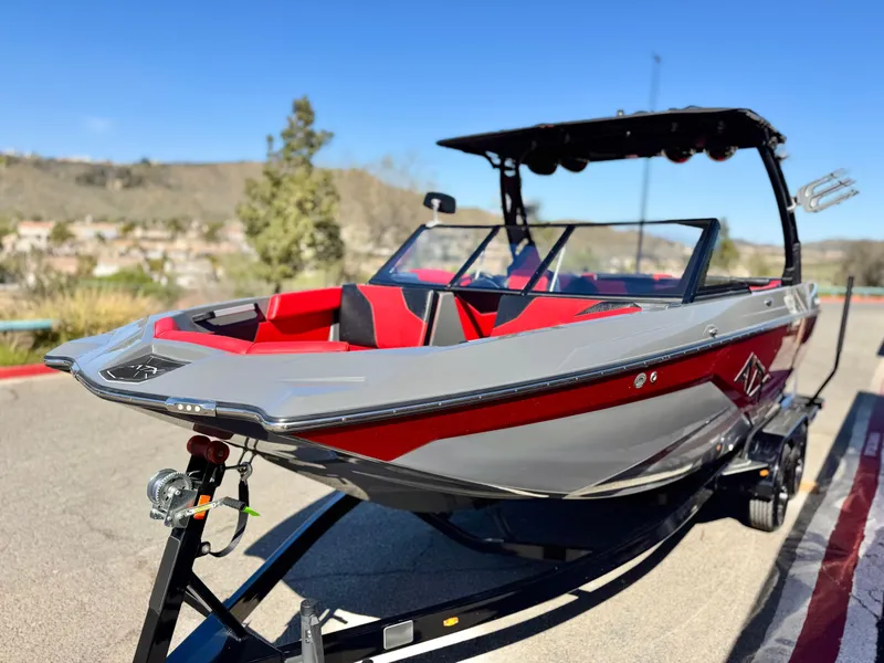 Slide: The Image of 2022 Tigé ATX 24 Type s boat with red and gray design on a trailer. - 3