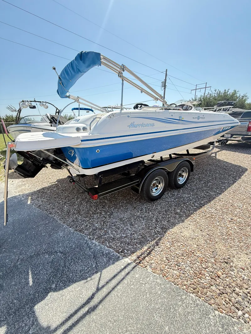 Slide: The Image of 2012 Hurricane 201 Sundeck Sport boat on trailer, parked outdoors under clear sky. - 3