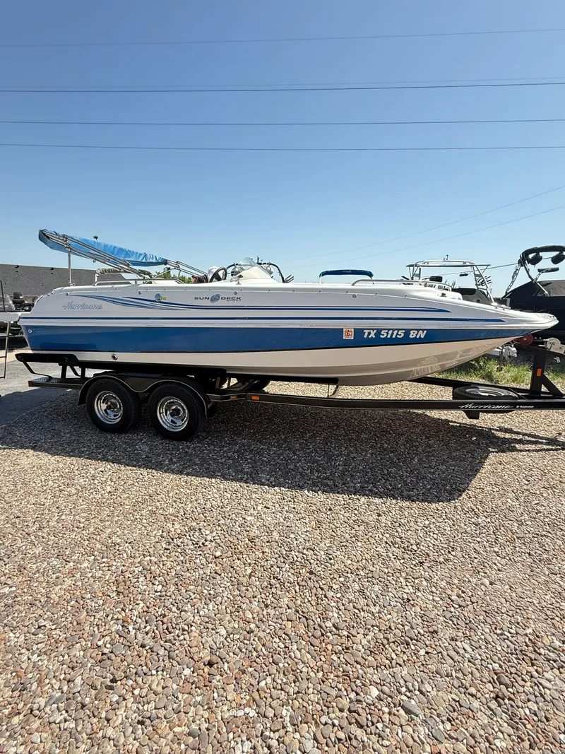 Slide: The Image of 2012 Hurricane 201 Sundeck Sport boat on trailer, parked on gravel. - 4