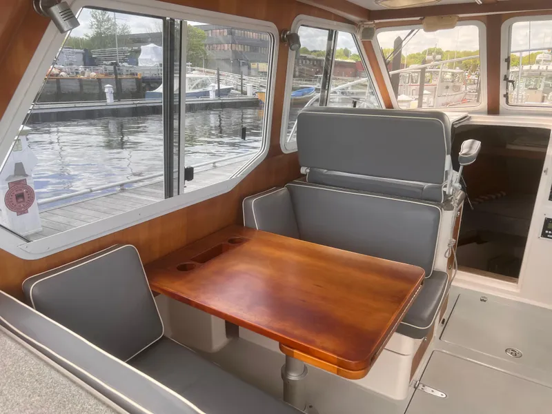 Slide: The Image of Interior of 2006 True North 38' Heritage boat with wooden table and gray seating. - 36