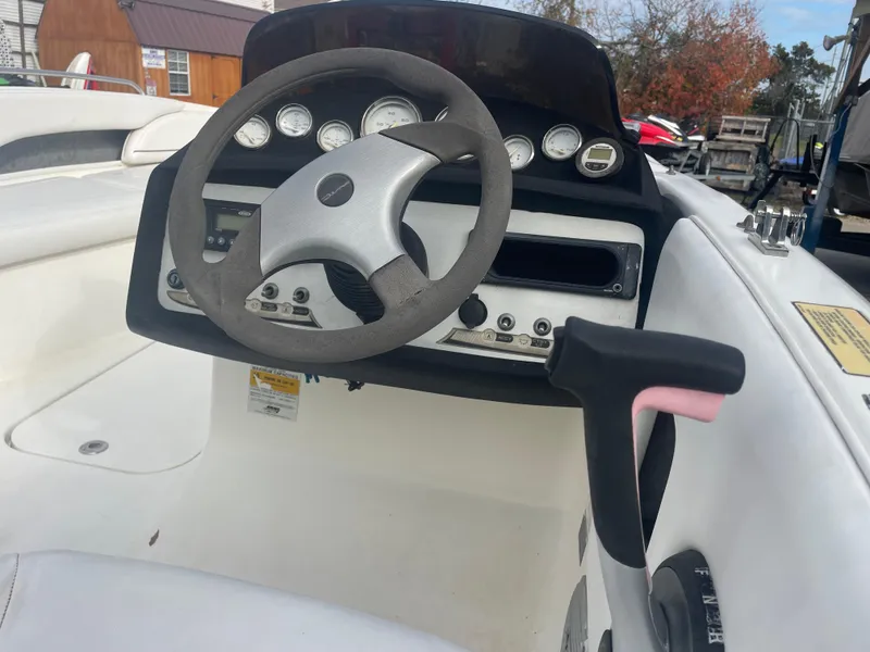 Slide: The Image of 2011 Bayliner 197 boat dashboard with steering wheel and control panel. - 11