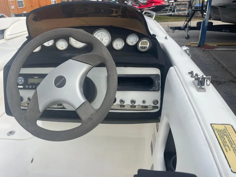 Slide: The Image of Steering wheel and dashboard of a 2011 Bayliner 197 boat, featuring gauges and controls. - 12