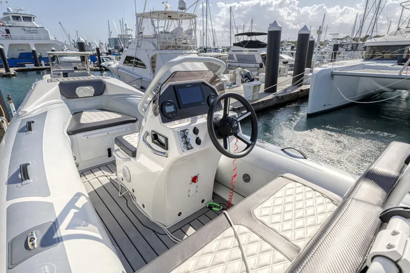 Slide: The Image of 2023 Aquila 54 Yacht docked in a serene marina setting with palm trees. - 105