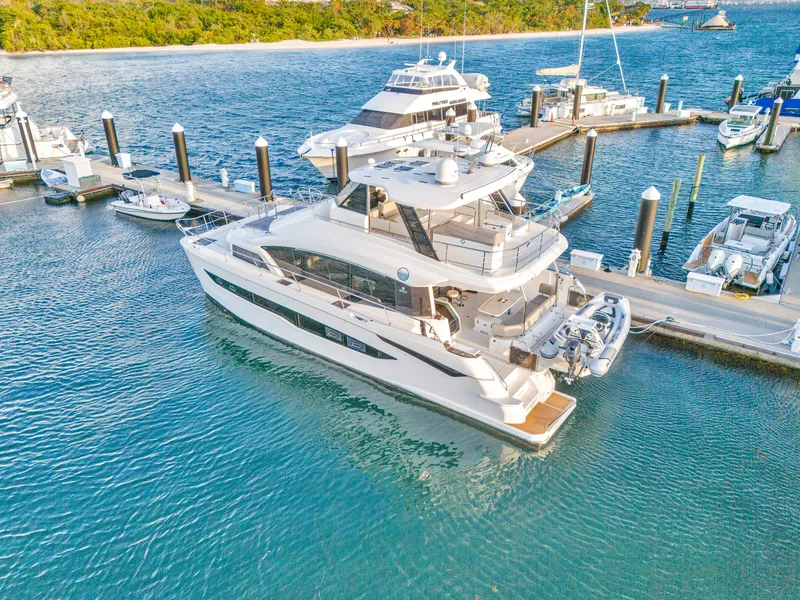 Slide: The Image of 2023 Aquila 54 Yacht docked in a tropical marina setting. - 106