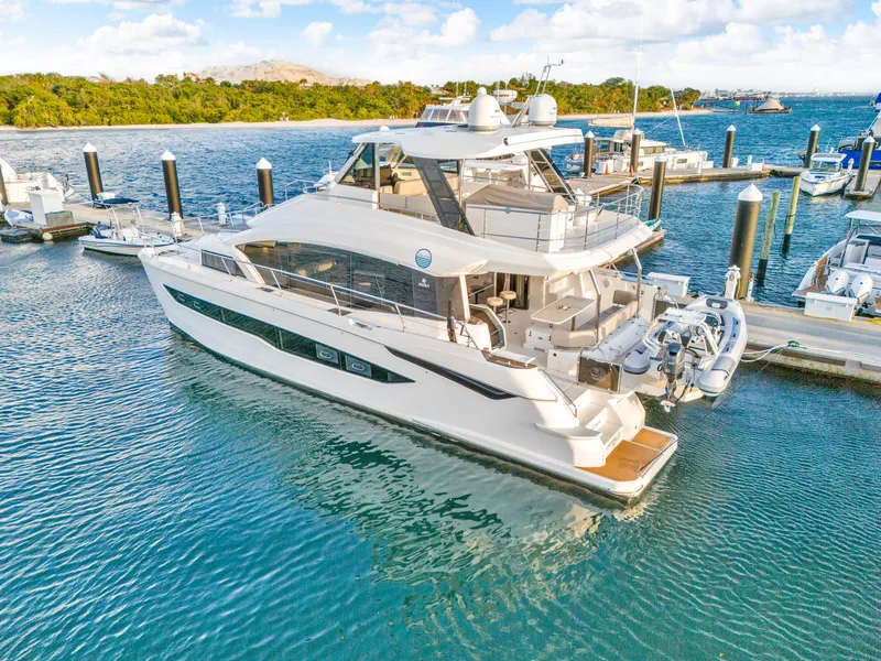 Slide: The Image of 2023 Aquila 54 Yacht docked in a serene marina setting. - 112