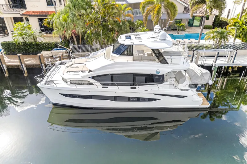 Slide: The Image of Aerial view of 2023 Aquila 54 Yacht docked beside lush palm trees. - 113