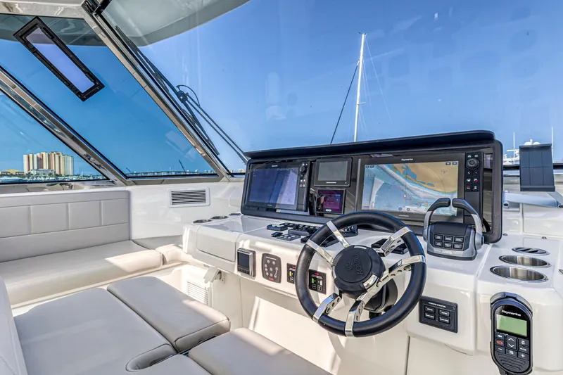 Slide: The Image of Control panel of 2023 Aquila 54 Yacht with navigation screens and steering wheel. - 12