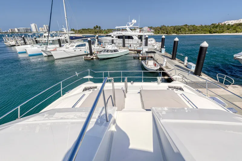 Slide: The Image of 2023 Aquila 54 Yacht with sun loungers, docked at marina under clear sky. - 43