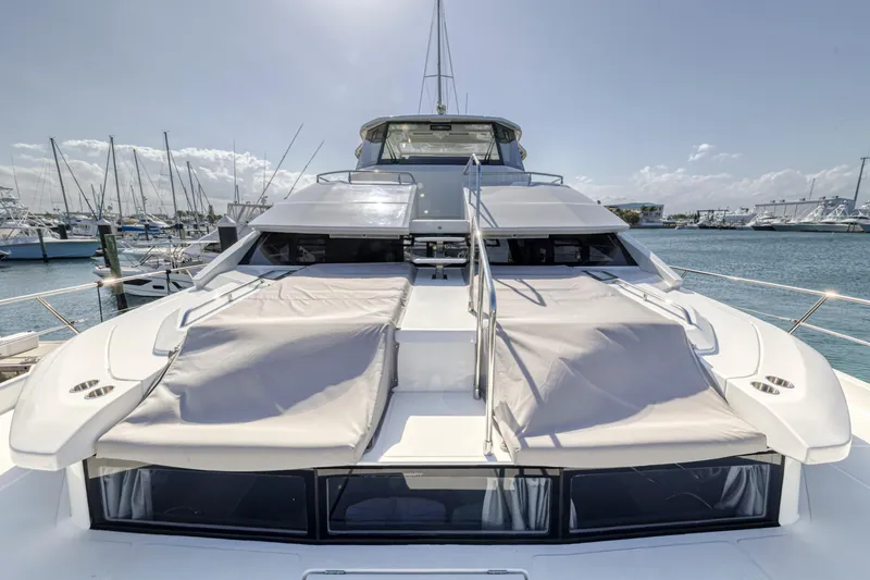 Slide: The Image of 2023 Aquila 54 Yacht docked at marina, showcasing sleek design and spacious deck. - 45
