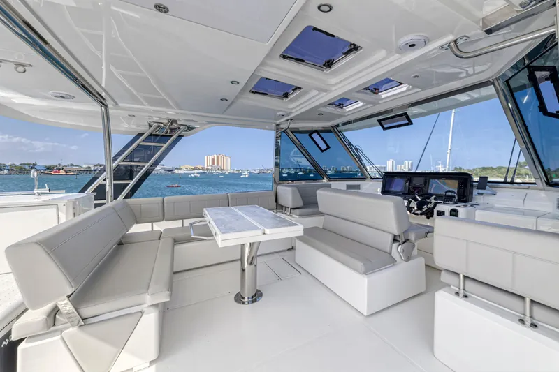 Slide: The Image of Aquila 54 Yacht 2023 deck with marina view, featuring seating and storage. - 9