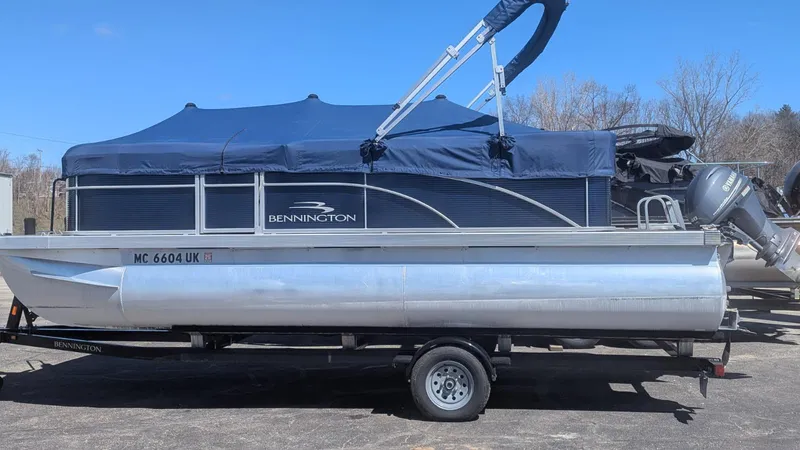 Slide: The Image of 2020 Bennington 20SLV pontoon boat with blue canopy on trailer. - 4