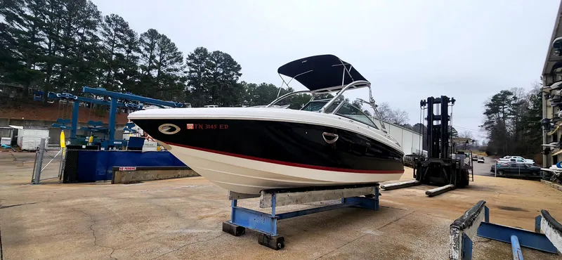 Slide: The Image of 2011 Cobalt 242 boat on a lift, surrounded by trees and equipment. - 6