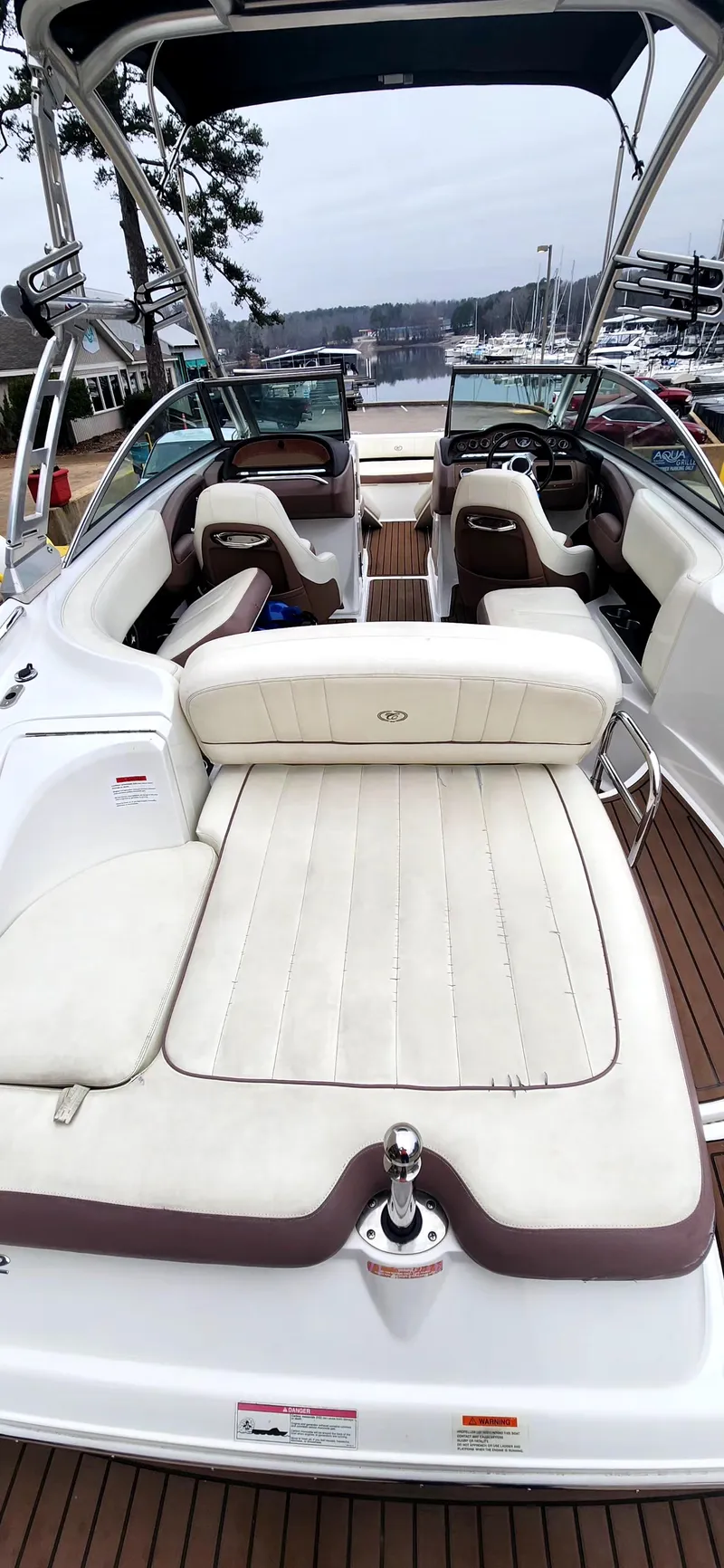 Slide: The Image of 2011 Cobalt 242 boat with white seating and wooden deck, docked at a marina. - 8