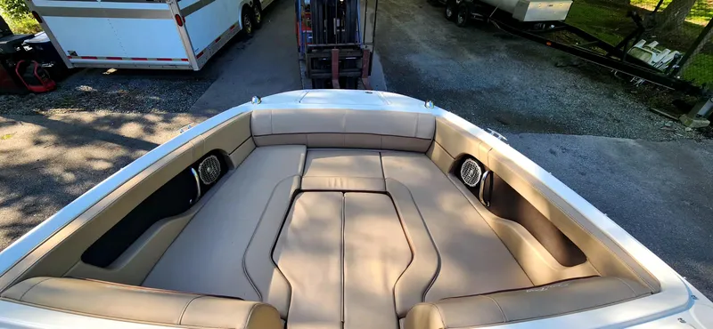 Slide: The Image of 2017 Sea Ray SDX 220 boat interior with beige seating and speakers, parked outdoors. - 15