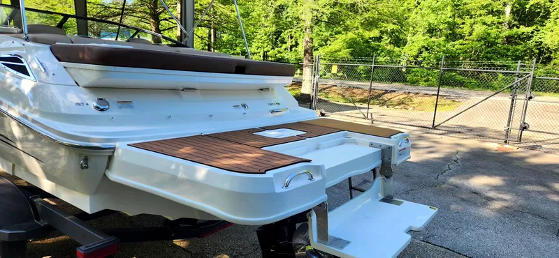 Slide: The Image of 2017 Sea Ray SDX 220 boat with swim platform, parked outdoors near a fence. - 8