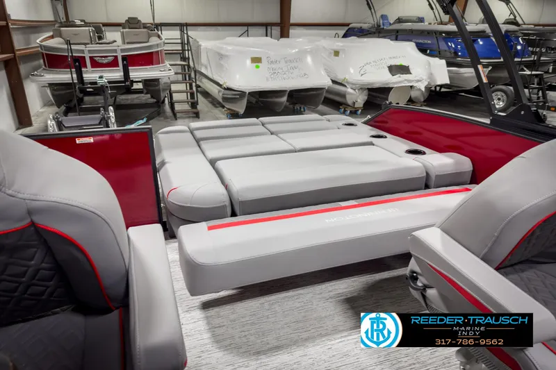 Slide: The Image of 2025 Bennington 24 MSB pontoon boat interior with gray and red seating in showroom. - 26