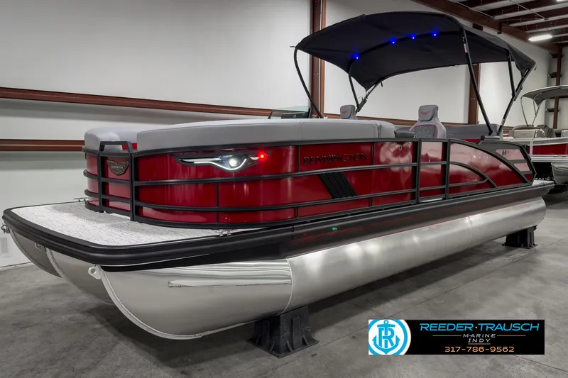 Slide: The Image of 2025 Bennington 24 MSB pontoon boat with red exterior and canopy in showroom. - 3