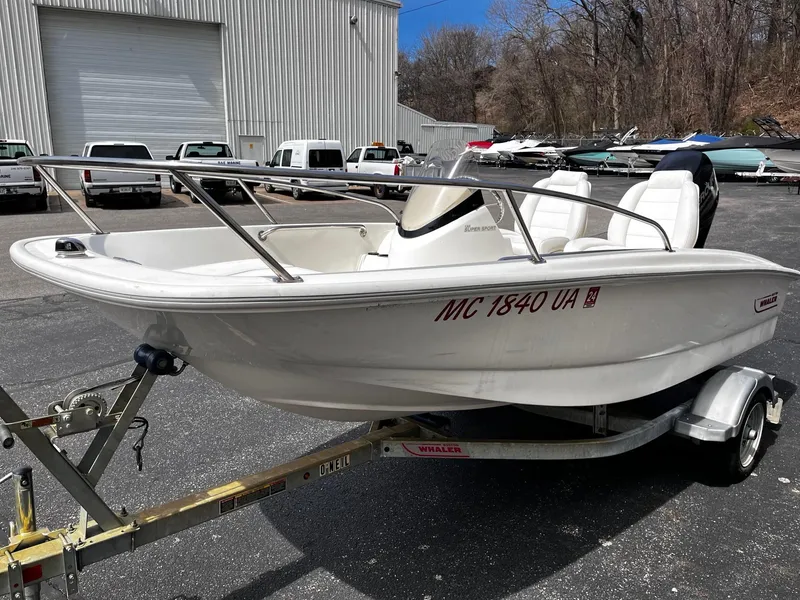 Slide: The Image of 2017 Boston Whaler 130 Super Sport boat on trailer in parking lot. - 3