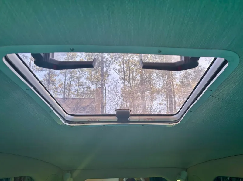 Slide: The Image of Sunroof view from inside a 1995 Sea Ray Sundancer boat, showing trees outside. - 10