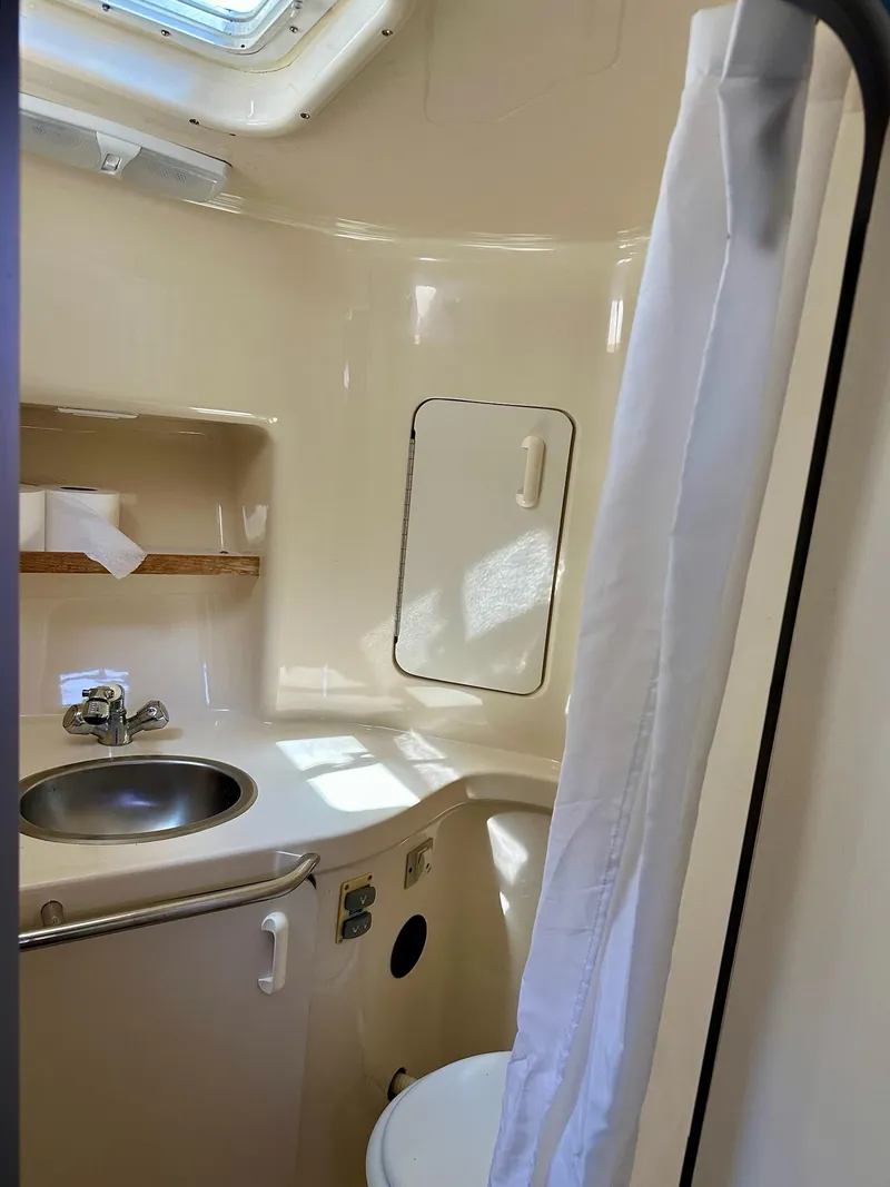 Slide: The Image of Bathroom interior of a 1995 Sea Ray Sundancer boat, featuring sink and shower. - 14