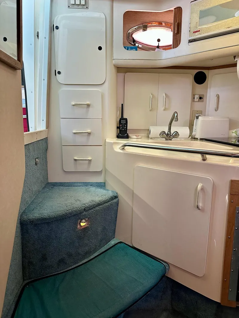 Slide: The Image of Interior of 1995 Sea Ray Sundancer boat with kitchenette and carpeted steps. - 17