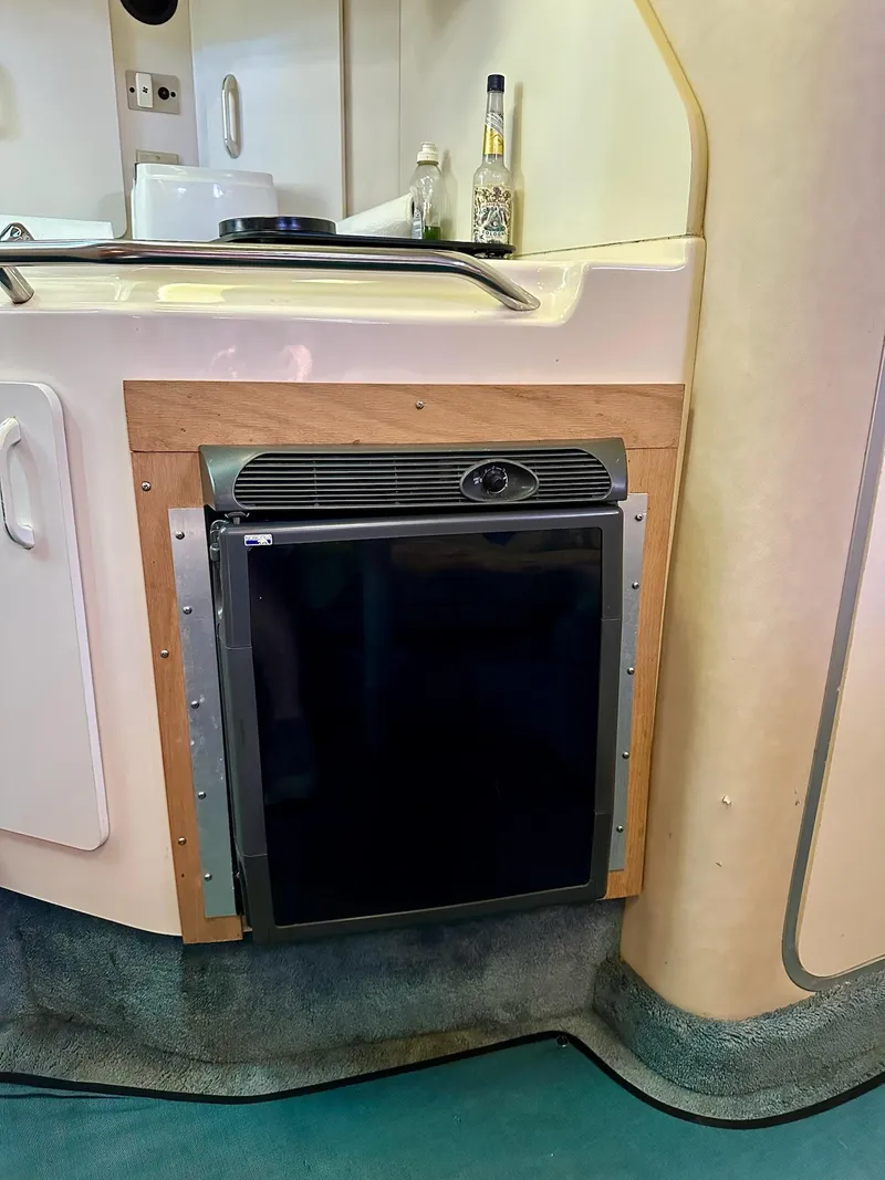 Slide: The Image of 1995 Sea Ray Sundancer interior with compact fridge and countertop. - 19