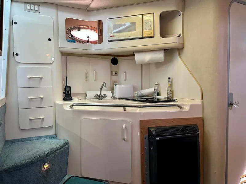Slide: The Image of Interior of a 1995 Sea Ray Sundancer boat kitchen with microwave and sink. - 21
