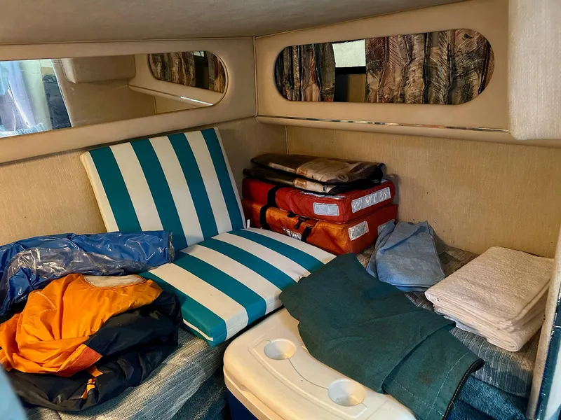 Slide: The Image of 1995 Sea Ray Sundancer cabin interior with striped cushions and life jackets. - 22