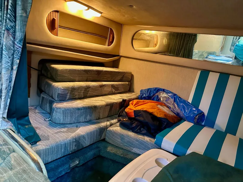 Slide: The Image of Interior cabin of a 1995 Sea Ray Sundancer boat with striped seating and cushions. - 23