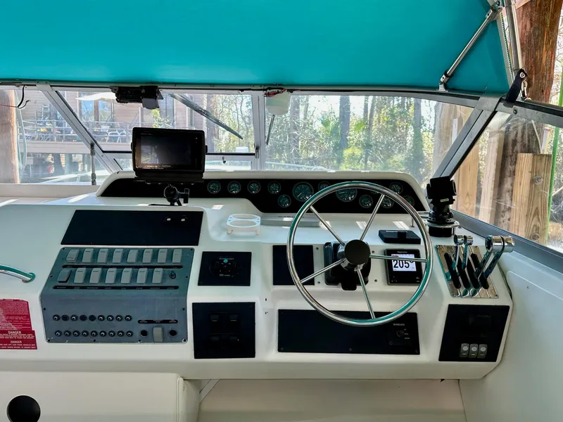 Slide: The Image of 1995 Sea Ray Sundancer helm with steering wheel, controls, and navigation equipment. - 25