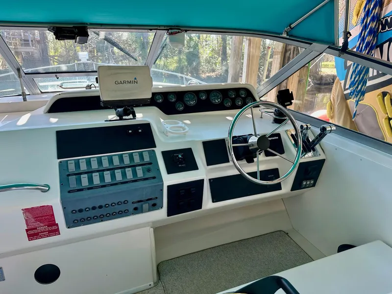 Slide: The Image of 1995 Sea Ray Sundancer helm with Garmin navigation, steering wheel, and control panel. - 26