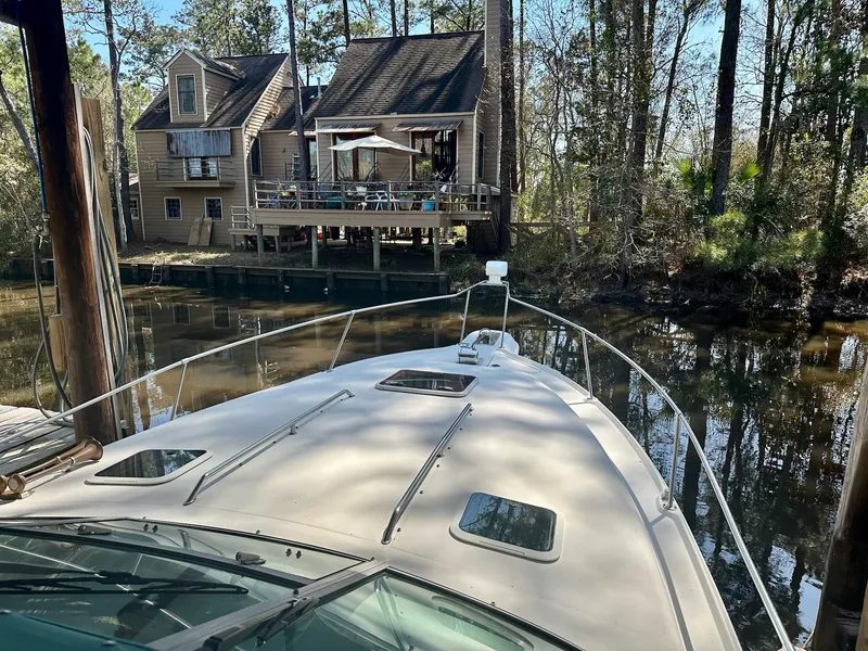 Slide: The Image of 1995 Sea Ray Sundancer docked near a rustic house by a wooded riverbank. - 6