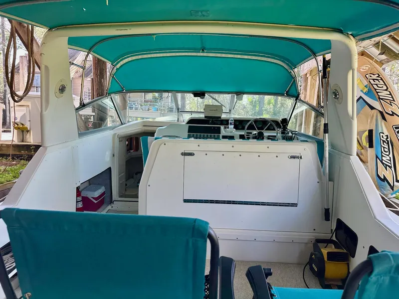 Slide: The Image of 1995 Sea Ray Sundancer boat interior with teal canopy and seating, featuring a steering wheel and dashboard. - 7