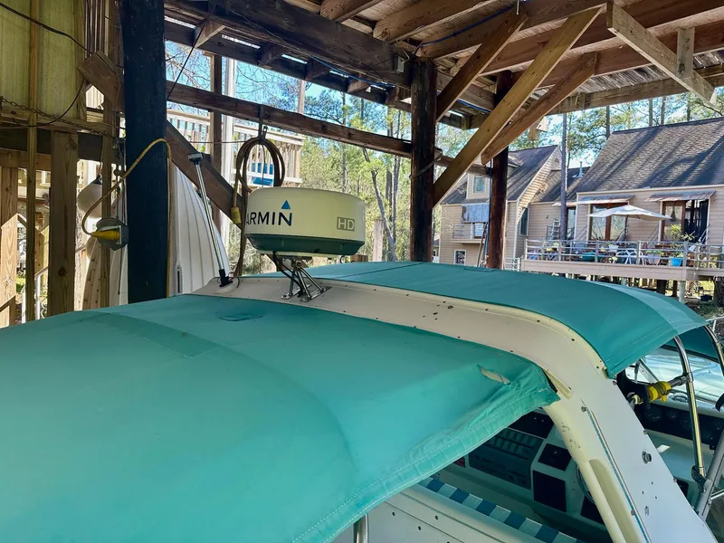 Slide: The Image of 1995 Sea Ray Sundancer with Garmin radar, docked under wooden shelter. - 9