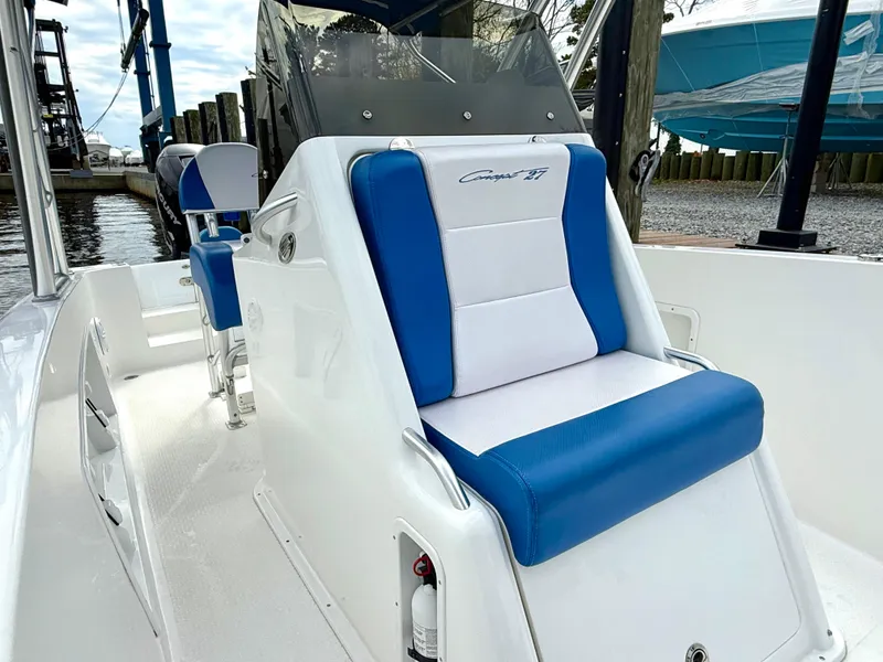 Slide: The Image of 2015 Concept 27' CC boat with blue and white seating, docked near water. - 11