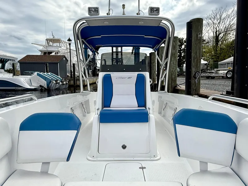 Slide: The Image of 2015 Concept 27' CC boat with blue and white seating, docked at a marina. - 12